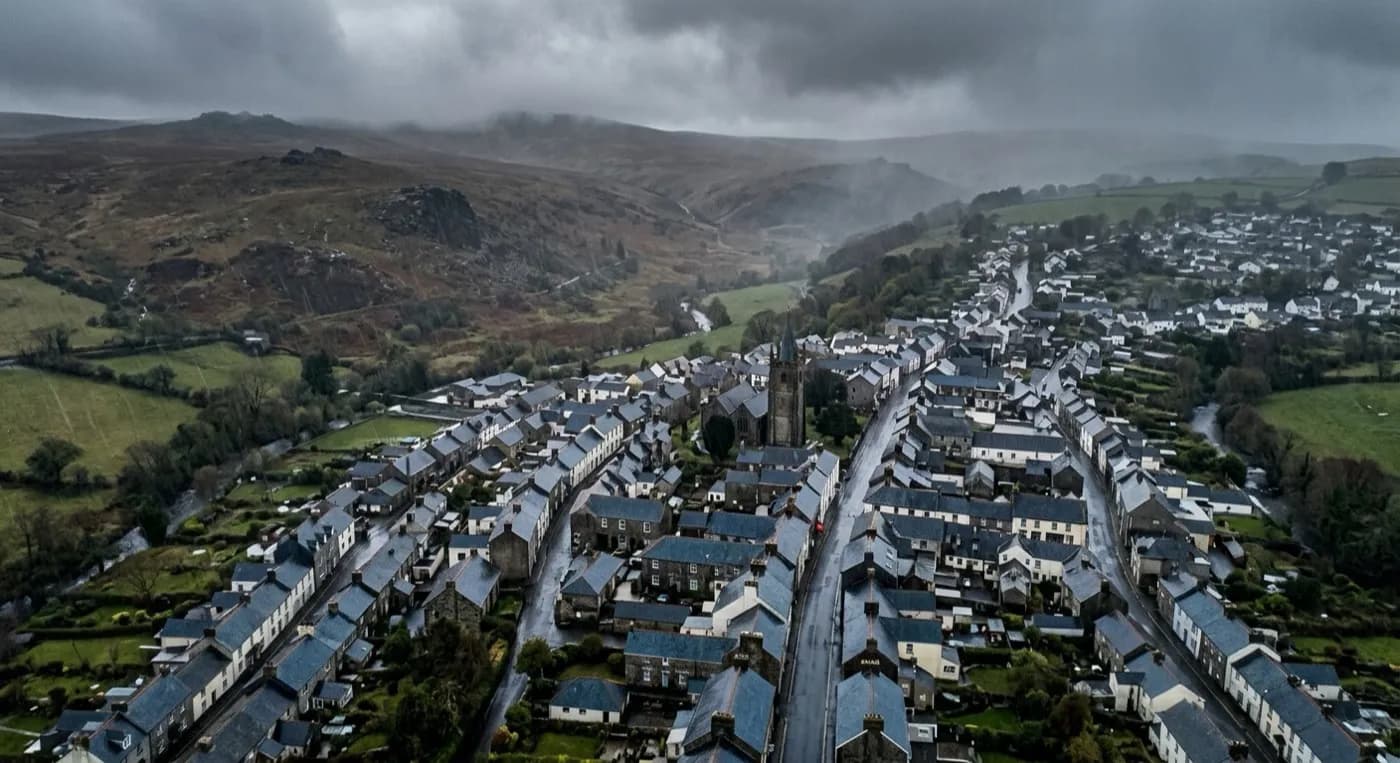 Aerial view of a Dartmoor-edge town taking driving rain off the high moor